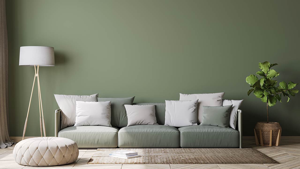 Image of Scandinavian home decor with green couch, rattan pot and floor lamp