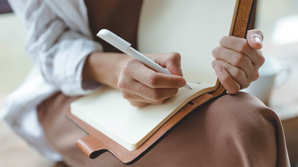 Photo of a woman writing in a notepad