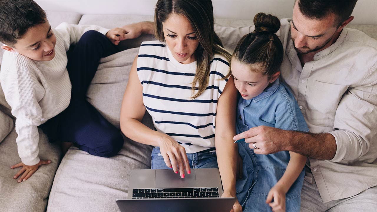Family on a sofa using a laptop