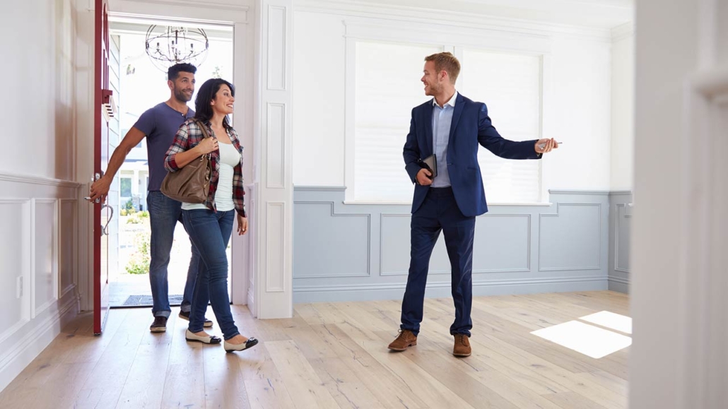Real estate agent showing a couple around new home