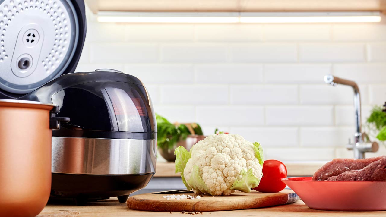 Modern pot with multicooker and products on kitchen table