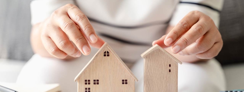 woman is deciding to choose house with Small Wooden House Model