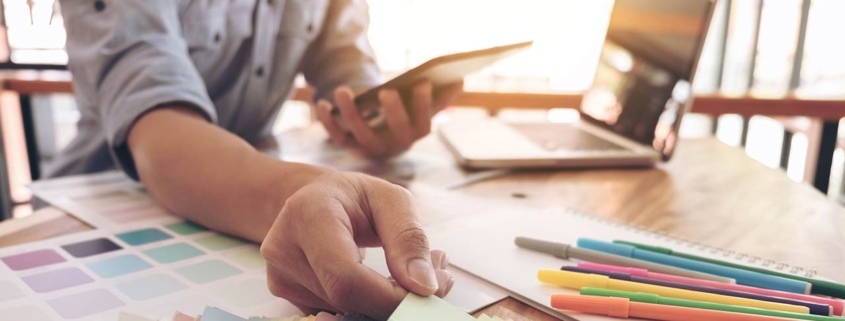 Man with laptop and paint swatches to select a new color